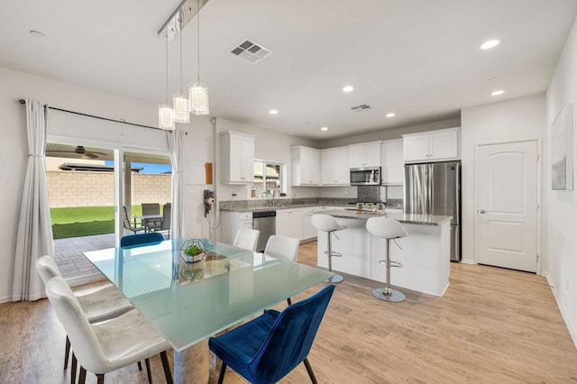 dining space with sink and light hardwood / wood-style flooring