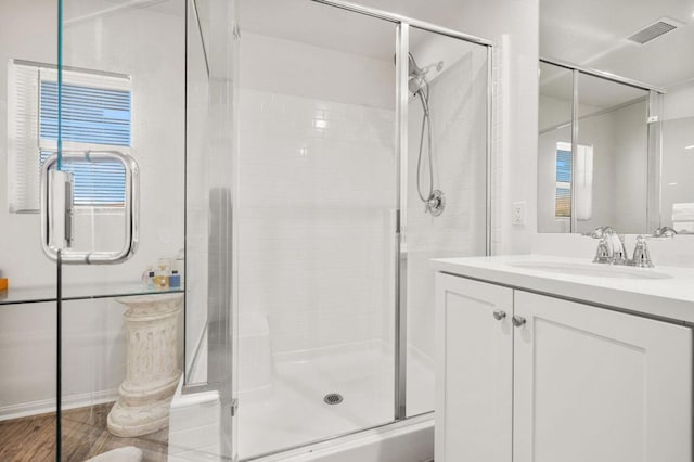 bathroom featuring vanity and a shower with door