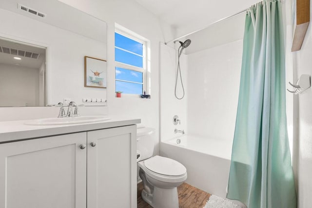 full bathroom with hardwood / wood-style floors, vanity, toilet, and shower / tub combo