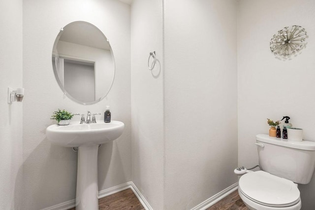 bathroom with wood-type flooring and toilet