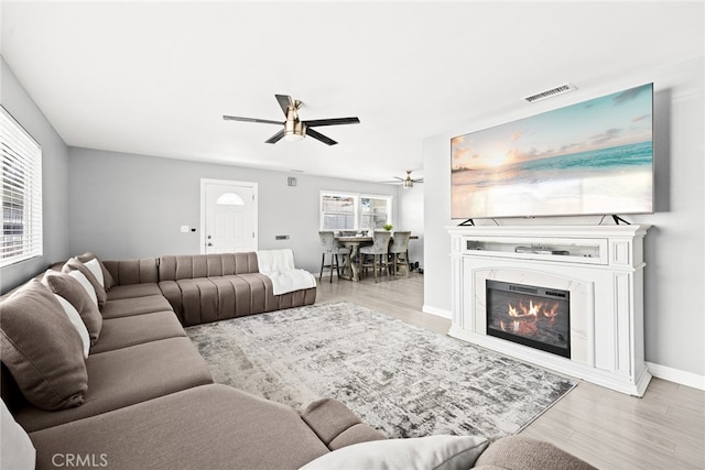 living room featuring light hardwood / wood-style floors, a wealth of natural light, and ceiling fan