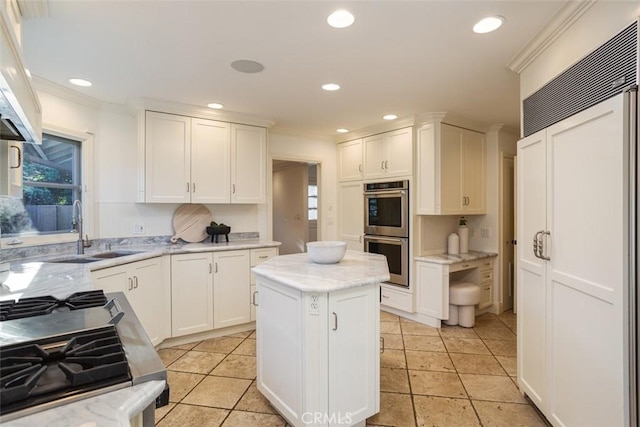 kitchen with a center island, stainless steel double oven, sink, and white cabinetry