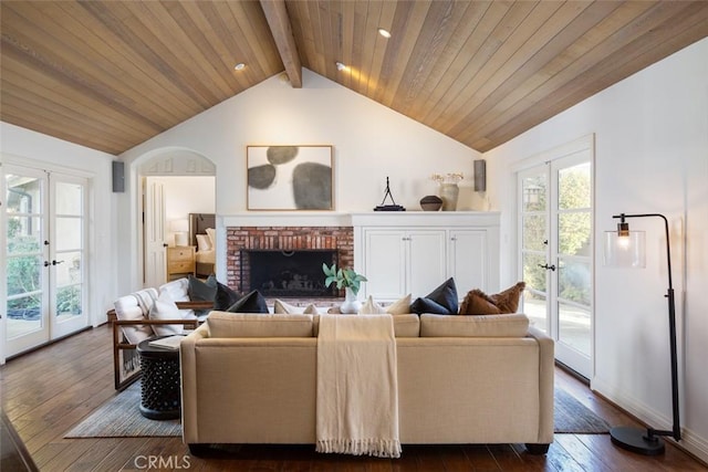 living room with french doors, a brick fireplace, dark wood-type flooring, wooden ceiling, and vaulted ceiling with beams