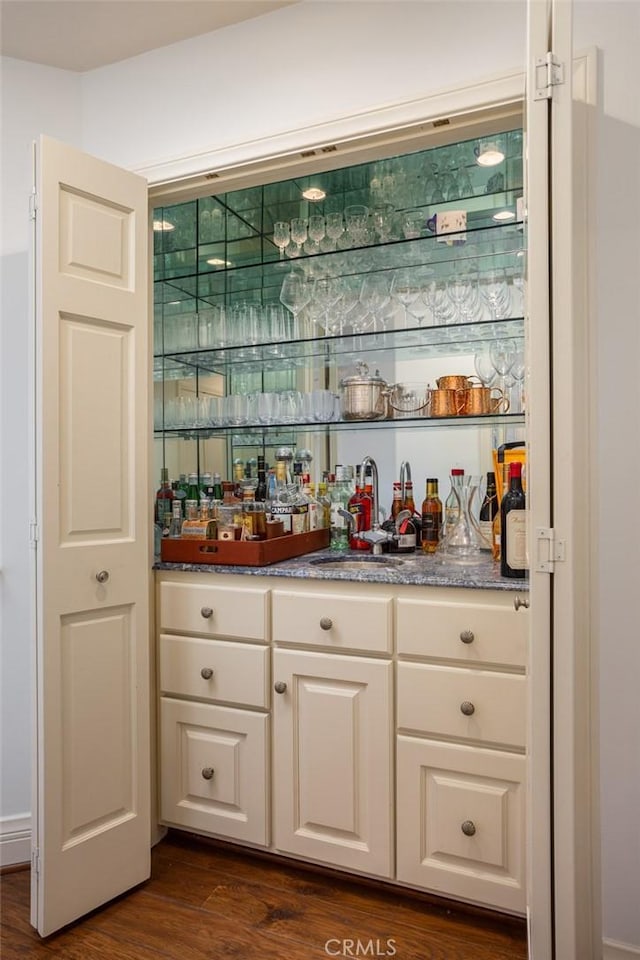 bar with white cabinets, dark hardwood / wood-style floors, and sink