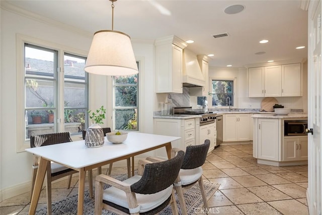 kitchen with premium range hood, white cabinets, decorative backsplash, decorative light fixtures, and stainless steel appliances