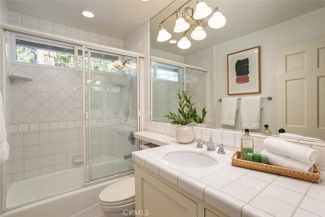 full bathroom with vanity, toilet, a notable chandelier, and bath / shower combo with glass door