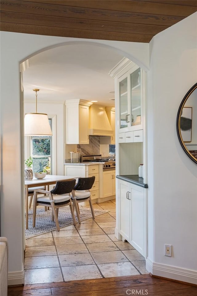 kitchen featuring white cabinetry, stainless steel gas cooktop, decorative light fixtures, decorative backsplash, and custom exhaust hood