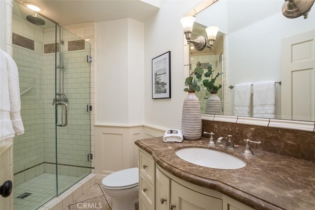 bathroom with vanity, a shower with door, an inviting chandelier, tile patterned floors, and toilet