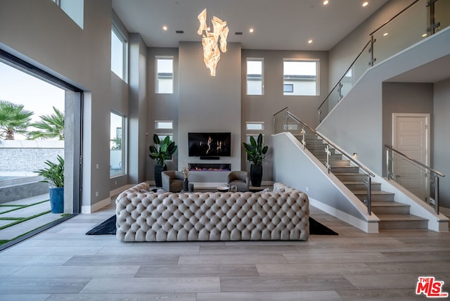 living room with light wood-type flooring and a high ceiling