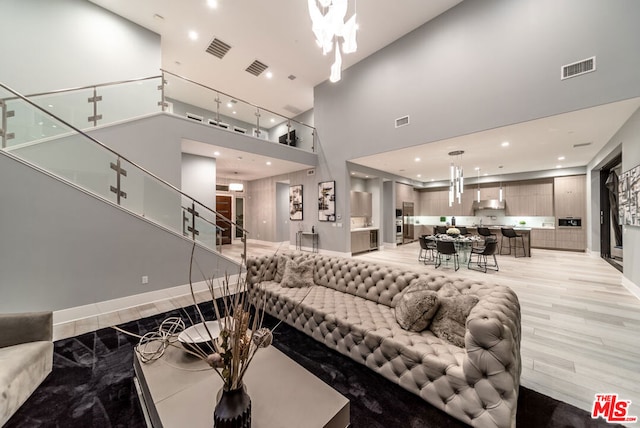 living room featuring a high ceiling and light hardwood / wood-style flooring