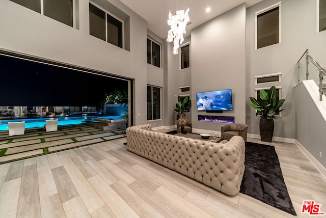 living room featuring light hardwood / wood-style floors and a towering ceiling