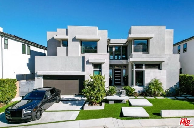 view of front facade featuring a garage, a balcony, and a front yard