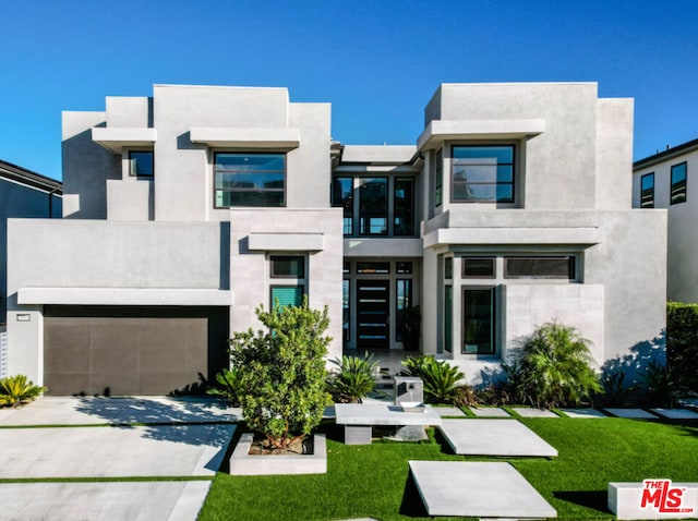 view of front of property with a front yard and a garage