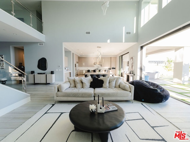 living room with a towering ceiling, hardwood / wood-style flooring, and plenty of natural light