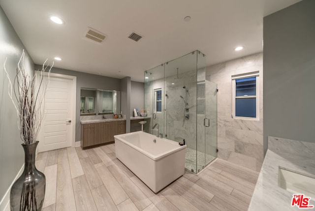 bathroom with hardwood / wood-style floors, vanity, and plus walk in shower