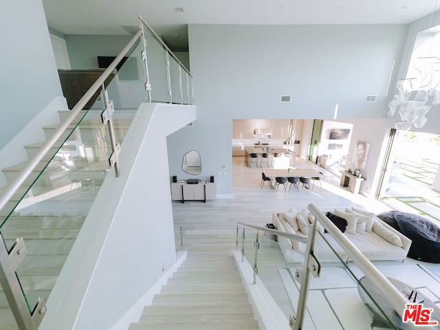 stairs with a high ceiling and hardwood / wood-style flooring