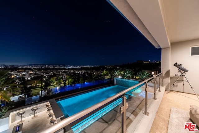 view of pool at twilight