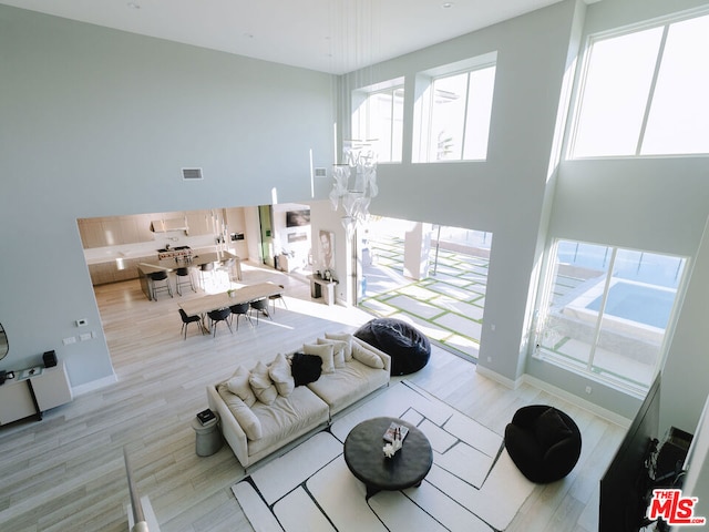 living room with a high ceiling and light wood-type flooring