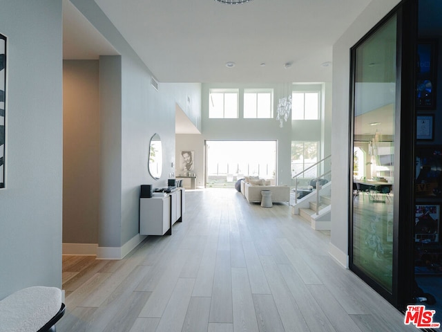 hall featuring a high ceiling and light wood-type flooring