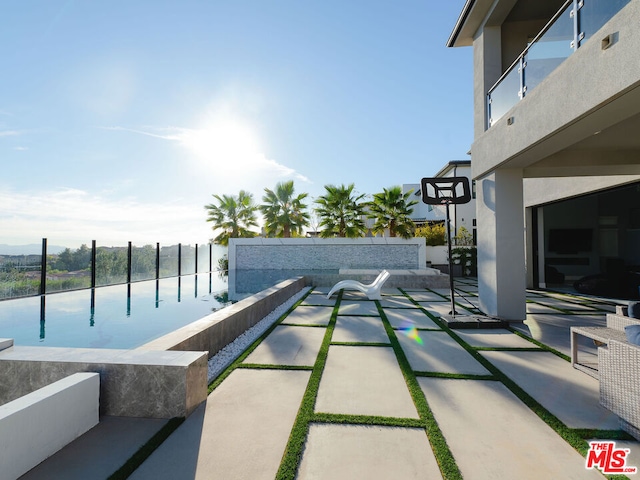 view of swimming pool featuring a patio area and a water view