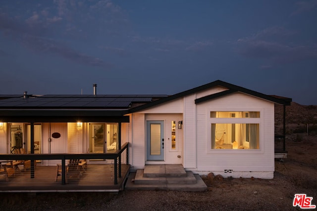 view of front of property featuring covered porch and solar panels