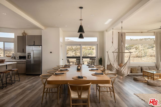 dining space with beam ceiling, hardwood / wood-style floors, and a healthy amount of sunlight