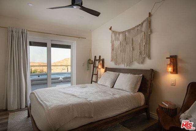 bedroom featuring dark wood-type flooring, a mountain view, access to outside, and ceiling fan