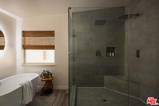 bathroom with plus walk in shower, vaulted ceiling, and hardwood / wood-style floors