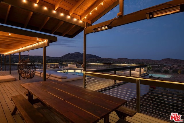 deck at dusk featuring a mountain view