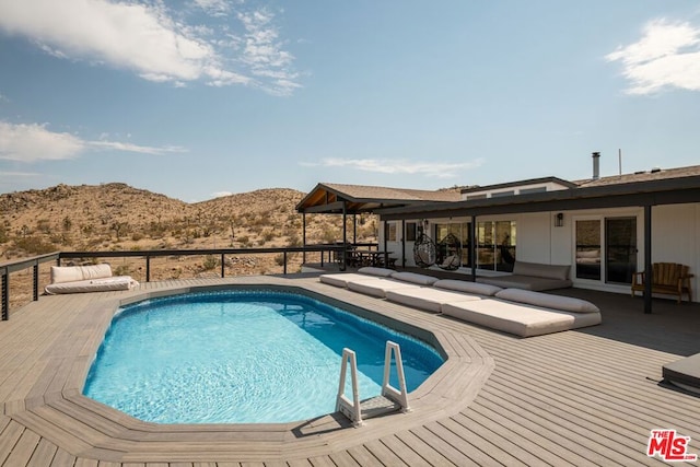 view of swimming pool featuring a deck with mountain view