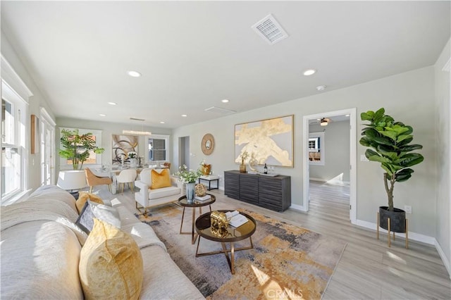 living room featuring light hardwood / wood-style floors and ceiling fan