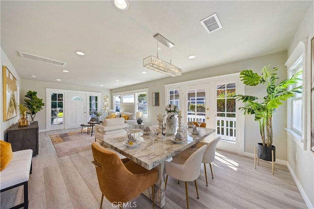 dining area with french doors and light wood-type flooring