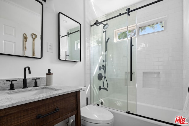 full bathroom featuring enclosed tub / shower combo, vanity, and toilet