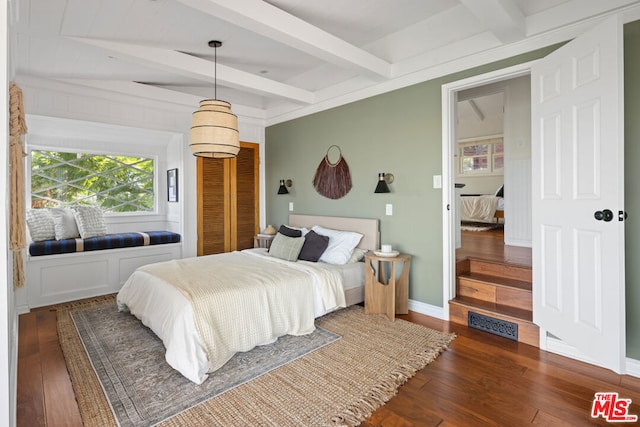 bedroom featuring dark hardwood / wood-style floors and beam ceiling