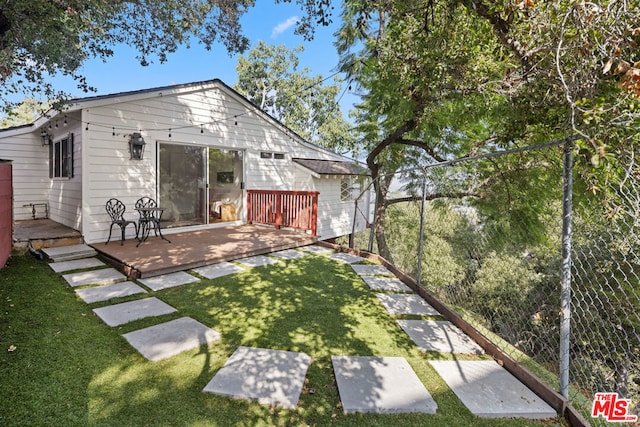 back of property featuring a yard and a deck