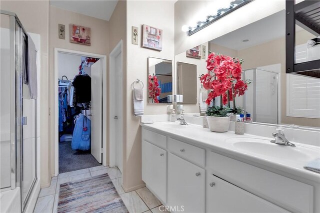 bathroom with tile patterned floors, a shower with door, and vanity