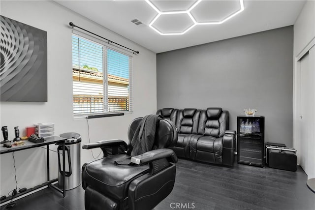 cinema room with beverage cooler and dark wood-type flooring