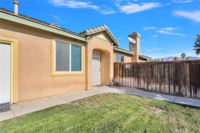 property entrance featuring a lawn