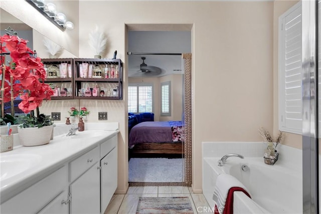 bathroom with ceiling fan, tile patterned flooring, vanity, and a washtub