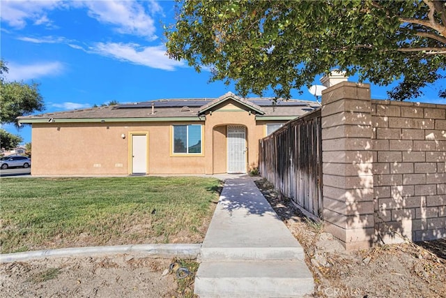 single story home with solar panels and a front lawn