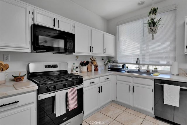 kitchen featuring light tile patterned flooring, appliances with stainless steel finishes, white cabinetry, and sink