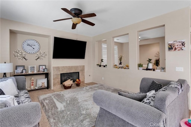 carpeted living room featuring a fireplace and ceiling fan