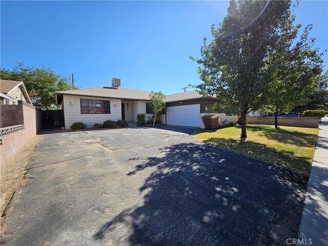 ranch-style home featuring a garage and central AC unit