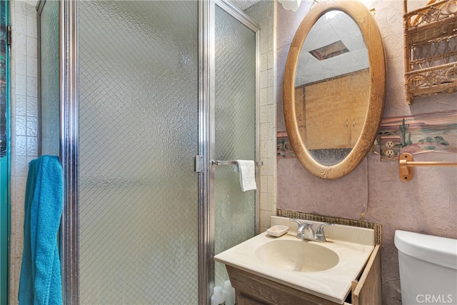 bathroom featuring vanity, toilet, and walk in shower