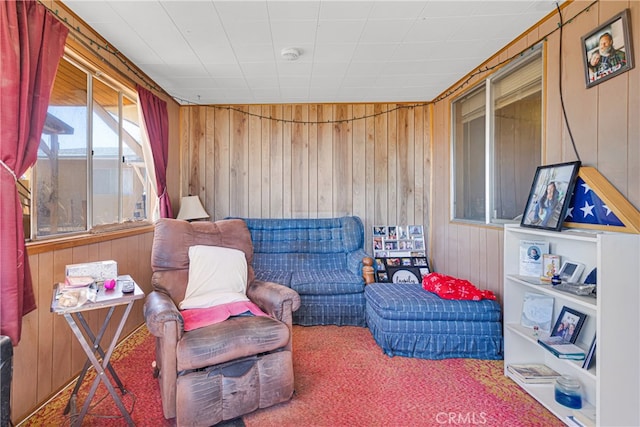 living area with carpet flooring and wooden walls