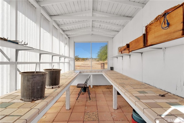 misc room featuring lofted ceiling with beams and light tile patterned flooring