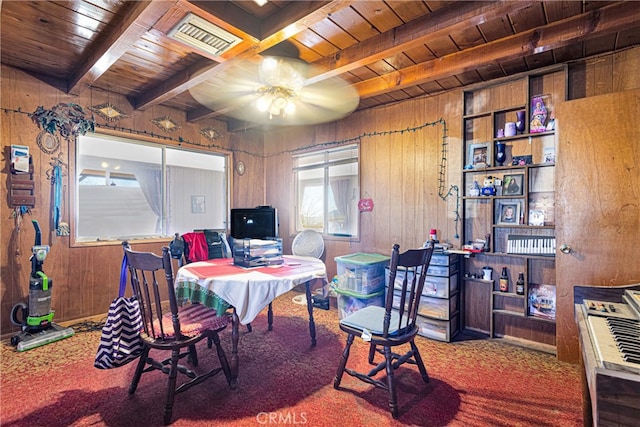 dining space with wood ceiling, carpet, ceiling fan, beamed ceiling, and wooden walls