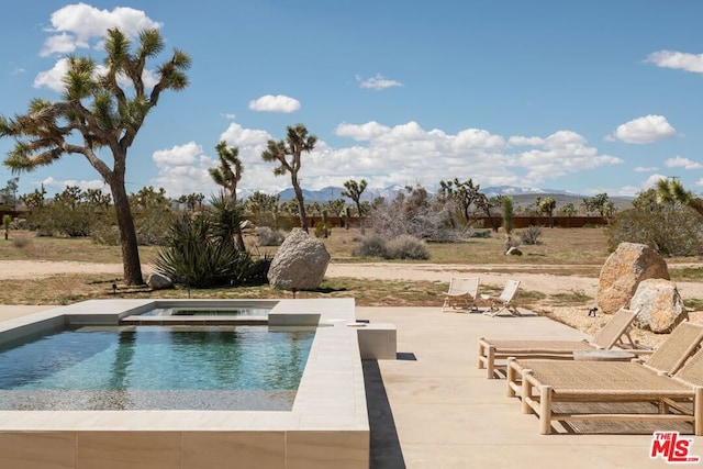 view of pool featuring an in ground hot tub, a mountain view, and a patio