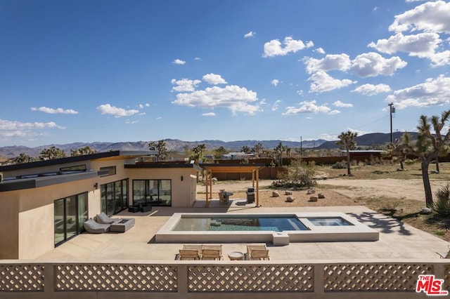 view of swimming pool featuring a patio, a mountain view, and an in ground hot tub