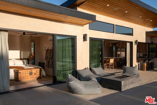 view of patio / terrace with ceiling fan and a fire pit